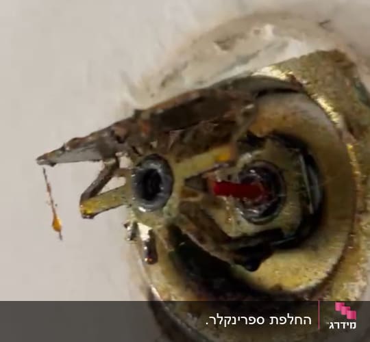 ברז חלוד עם נזילה על קיר לבן
